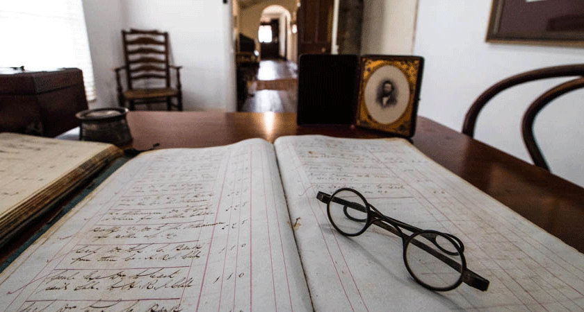 The view from Dr Christopher Penfold's desk in the Grange cottage. Original handwritten logbook appears under reading glasses