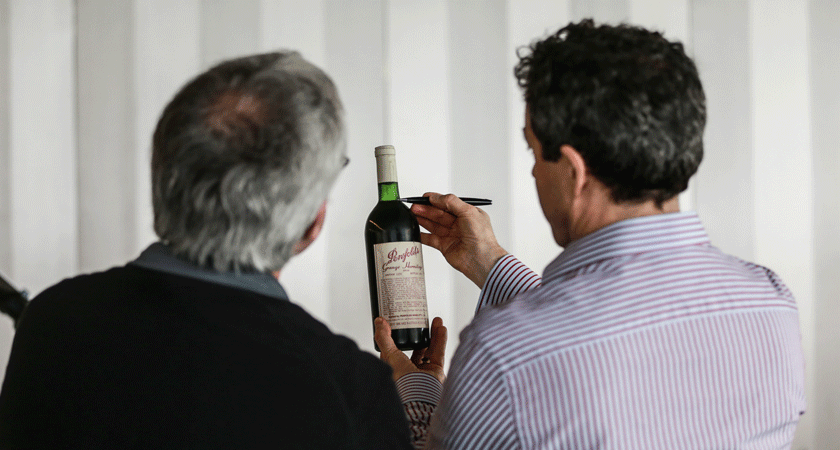 Peter Gago checks ullage level of a Penfolds wine bottle 