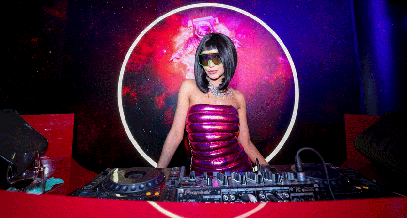 DJ Farah Farz in the booth at the Penfolds event in Singapore. She wears a pink metallic top and sunglasses