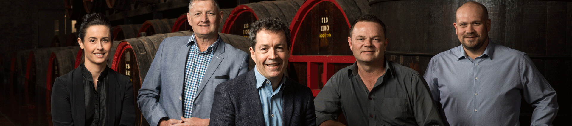 Penfolds winemaking team with barrels behind
