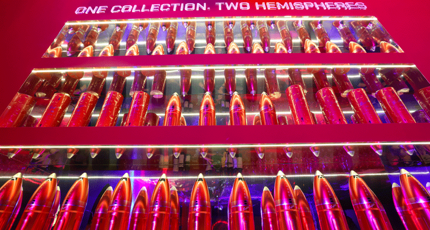 'One Collection.  Two Hemispheres.' appears above the bar. Three lines of shelves display rocket tin products.