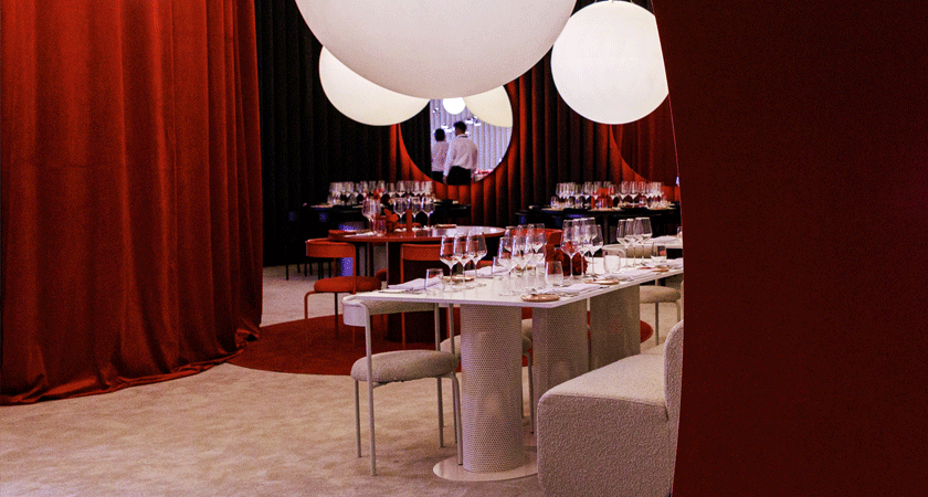 Interior view of Penfolds pop up restaurant.  Heavy red curtain pulled back  to reveal white tables