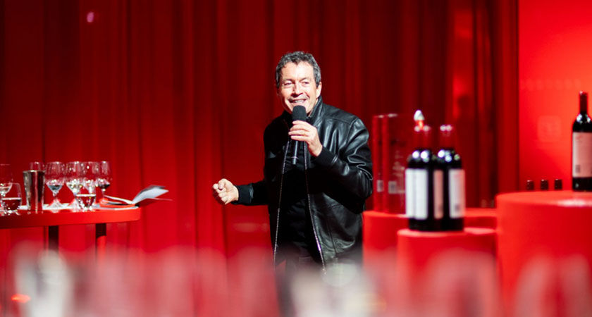 Chief Winemaker, Peter Gago, Stands in the middle of a red room presenting a wine masterclass