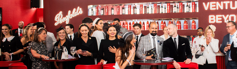 The red bar of the Penfolds Marquee with people mingling in front
