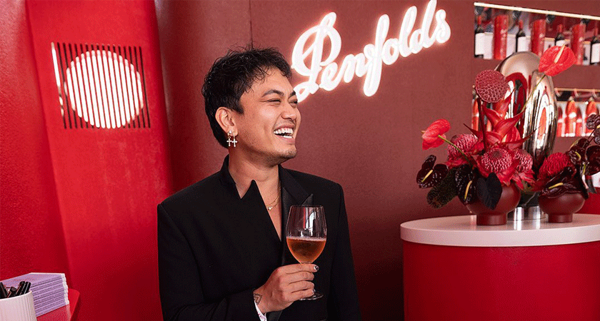 Chef, Khang Ong laughs holding a glass of rose wine