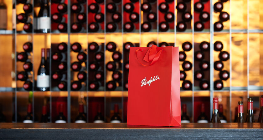 Penfolds gift bag placed on bar with Penfolds wines behind