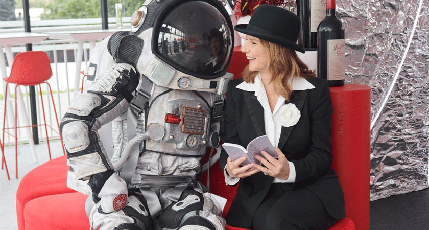 Actress Rachel Griffiths reads race form guide with astronaut