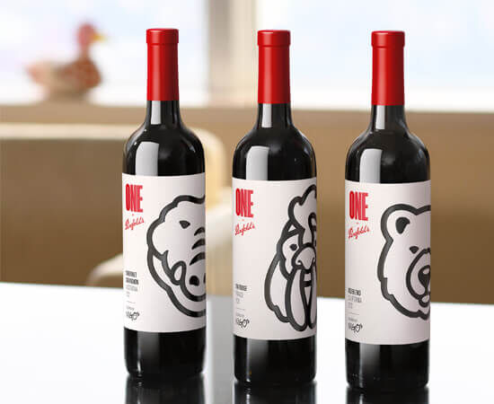 Three wine bottles on a table with black & white graphics on the label