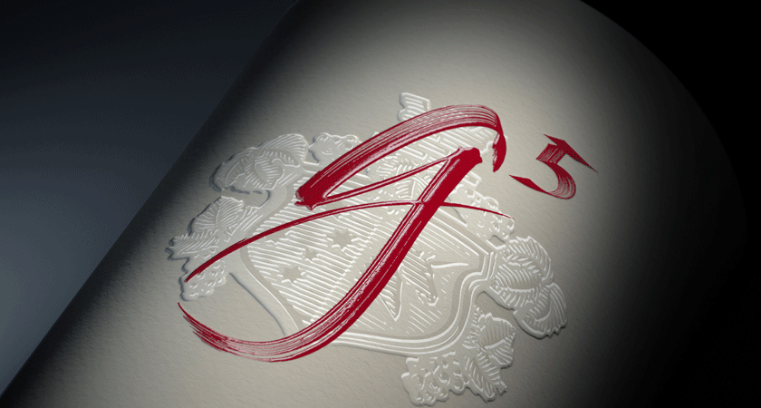 Close up of Penfolds g5 front label.  Red calligraphy script shows g 5.  A embossed cream crest is visible behind. 