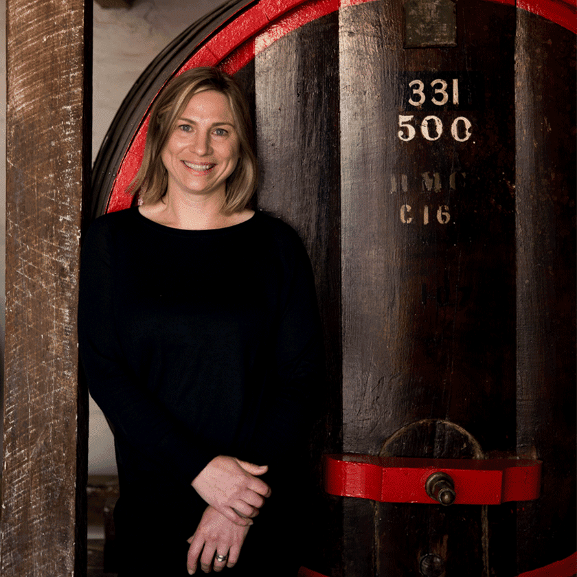Emma Wood, Penfolds Winemaker, stands in front of a large wine aged wine vat