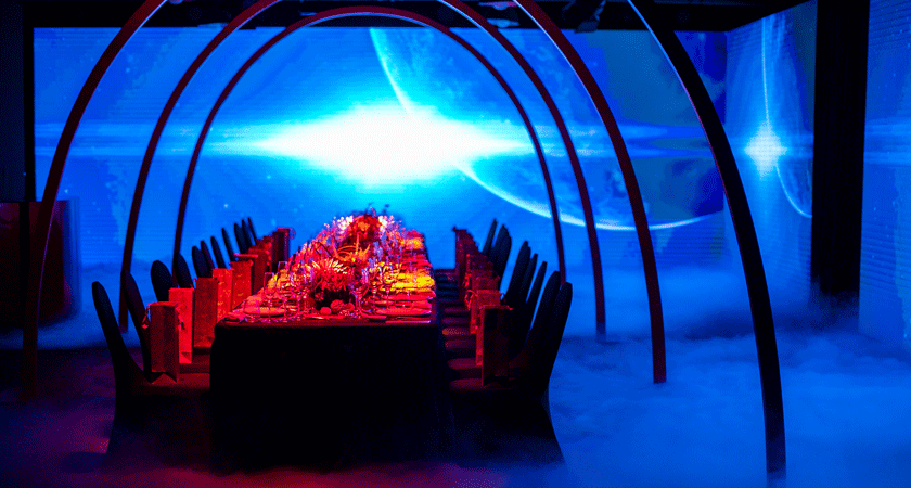 Dinner table surrounded by blue space themed LED screens