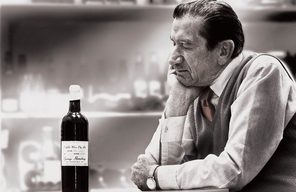 An older Max Schubert looks at an early release Grange bottle
