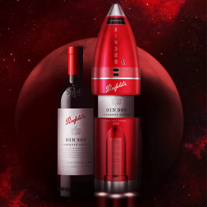 Bin 389 Wine Bottle beside red rocket tin. Tin is partially open to reveal a Bin 389 bottle inside.