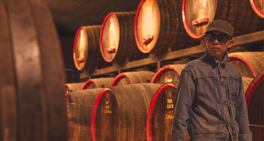 Nigo walks past large St Henri barrels.