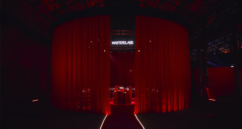 Red sheet curtains with a large round tasting table visible behind
