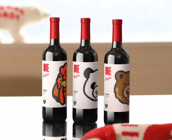 Three wine bottles on a table with coloured animal graphics on the label