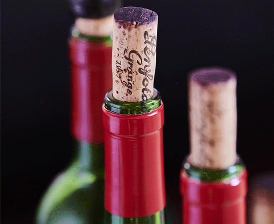 The top of three Penfolds bottles with cork sticking out