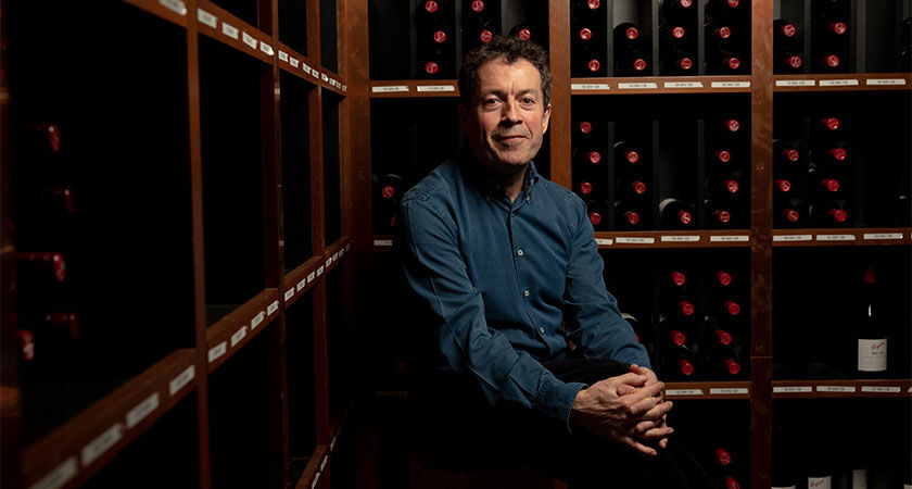 Peter Gago sitting amongst cellared Penfolds wines